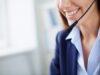 Lächelnde Frau mit Headset im Kundenservice.